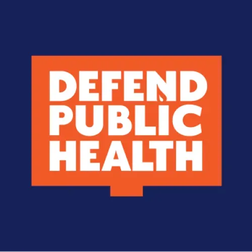 Logo for Defend Public Health. It has a blue background with an orange sign shape that says "defend public health" in white. 